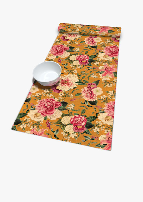 Camino de mesa con diseño floral sobre fondo ocre
